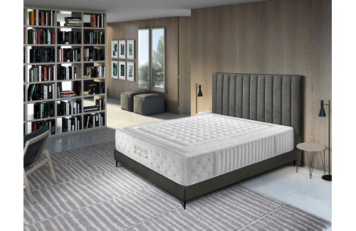 Colchón Legend blanco con base gris oscuro en dormitorio moderno con cabecero tapizado